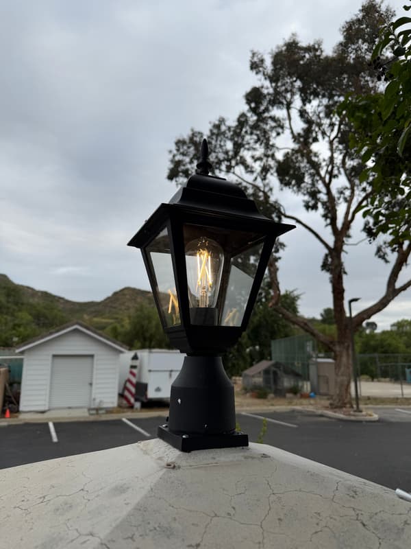 Black post-top lantern fixture installed outdoors